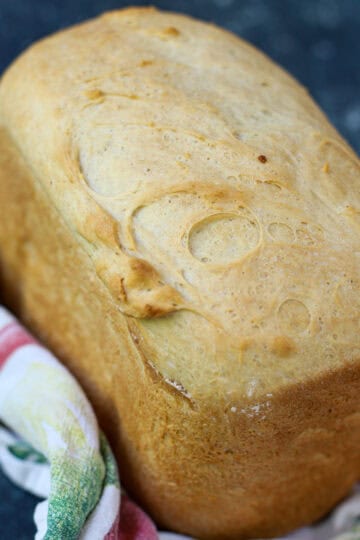 Freshly baked cottage cheese bread in a bread machine pan, with a light golden crust.