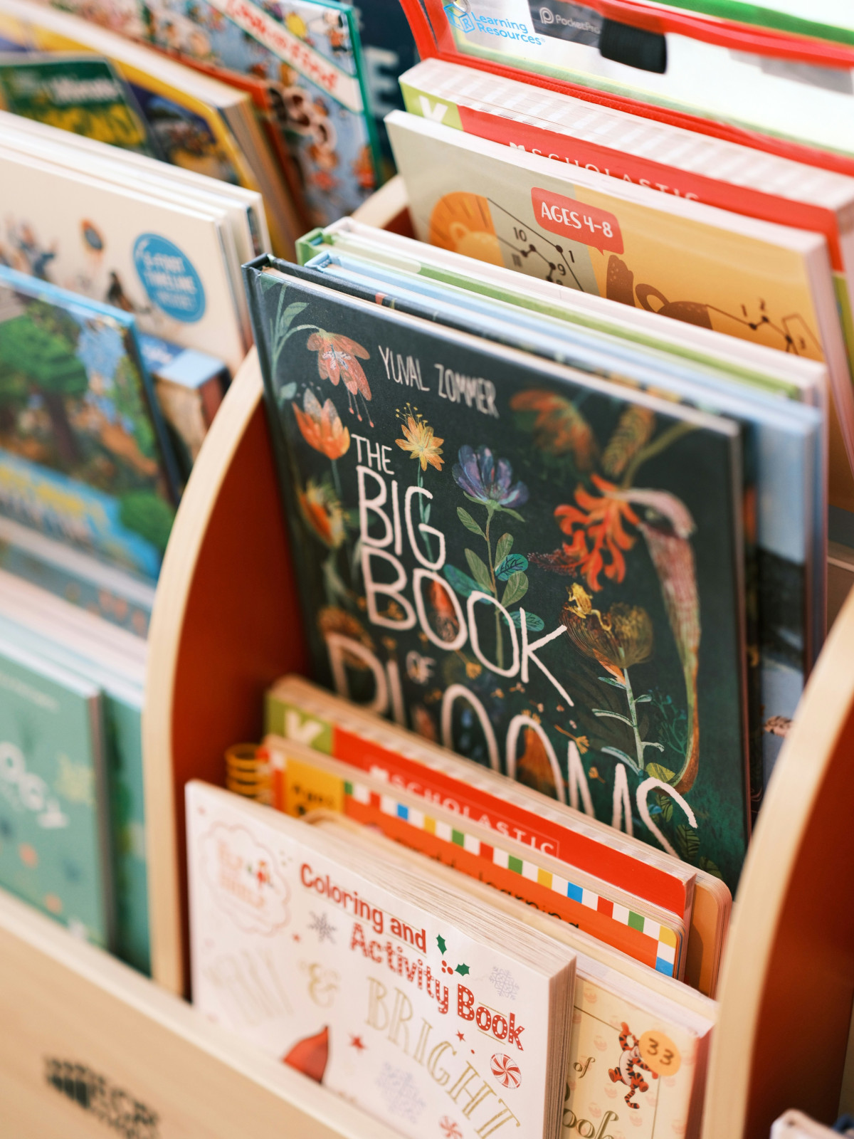 Children’s bookshelf filled with colorful gardening and nature books, including The Big Book of Blooms and activity books for ages 4 to 8.