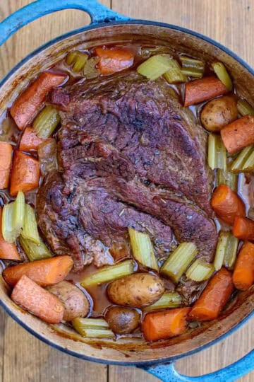 Overhead view of a Dutch oven pot roast with braised chuck, carrots, celery, and potatoes