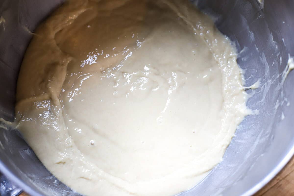Smooth, thick spaetzle batter in a stainless steel mixing bowl, ready to press into boiling water
